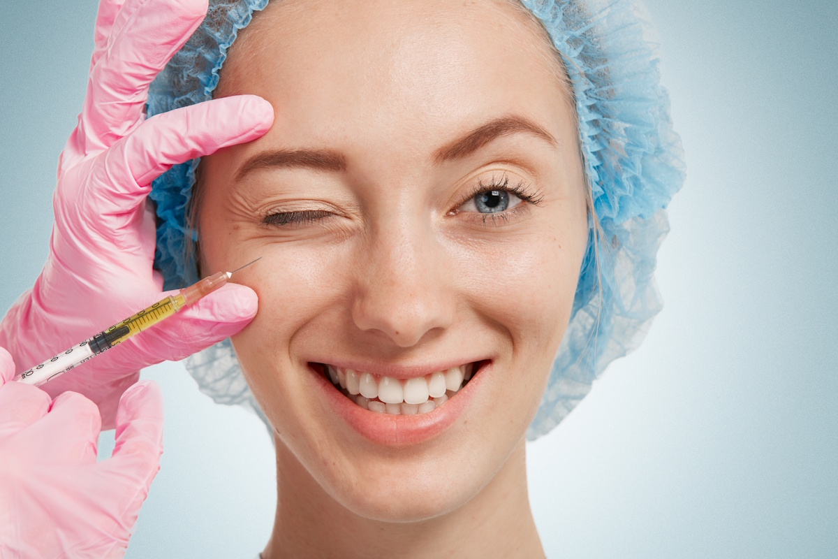 Medic dermatolog care injecteaza botox unei femei, in jurul ochilor